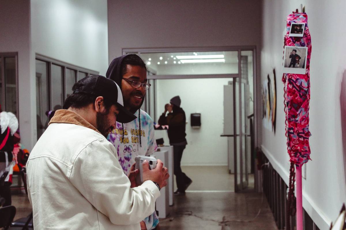 Students smiling and viewing a piece of artwork inside Art Wrecker.