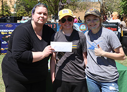 Two happy winners get presented an award envelope