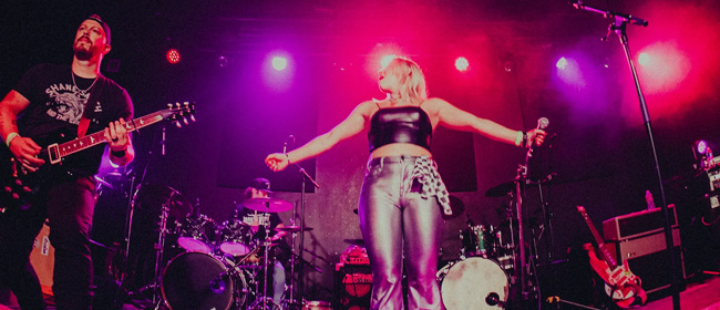 Band on stage with pink and purple lighting