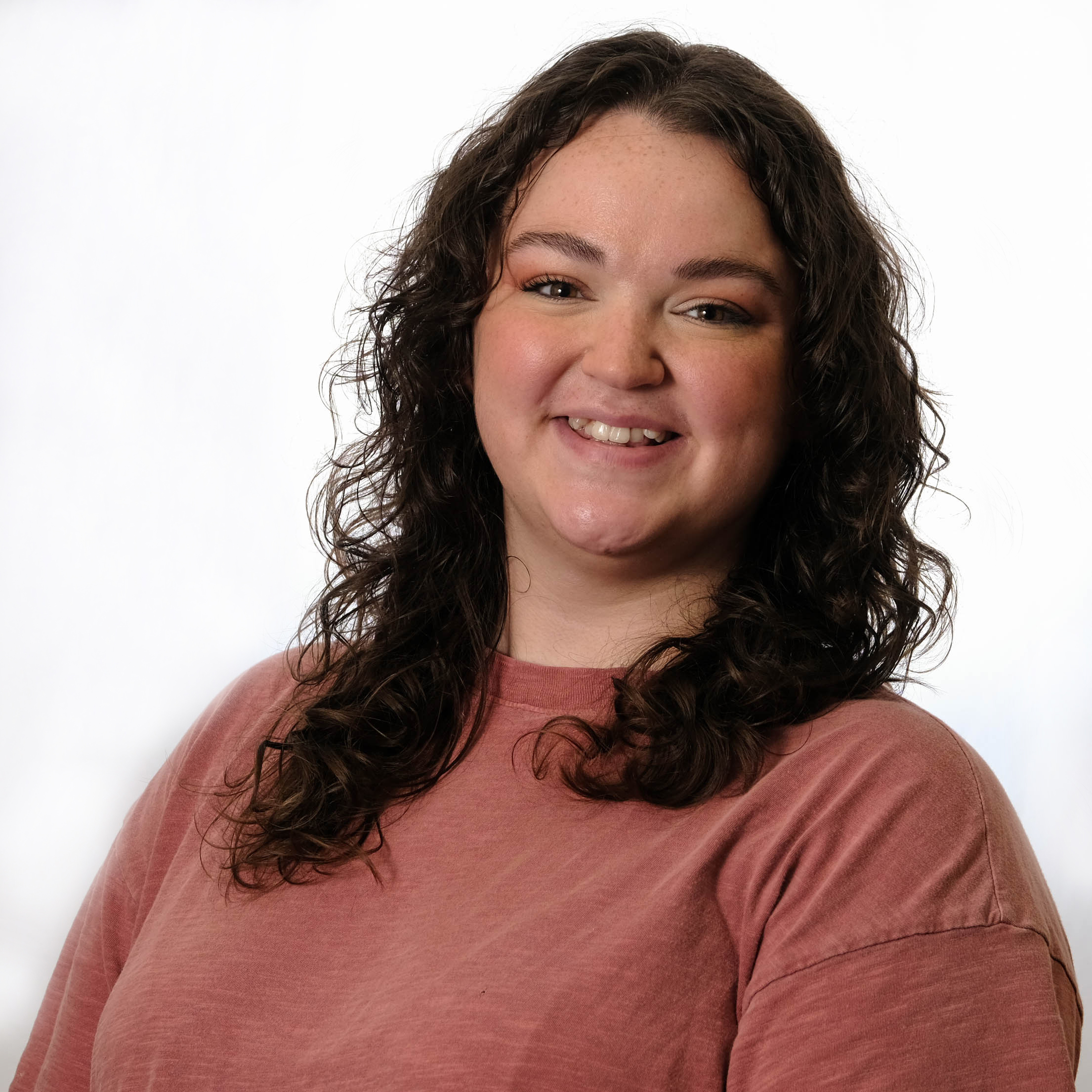 Smiling woman in a brick colored shirt