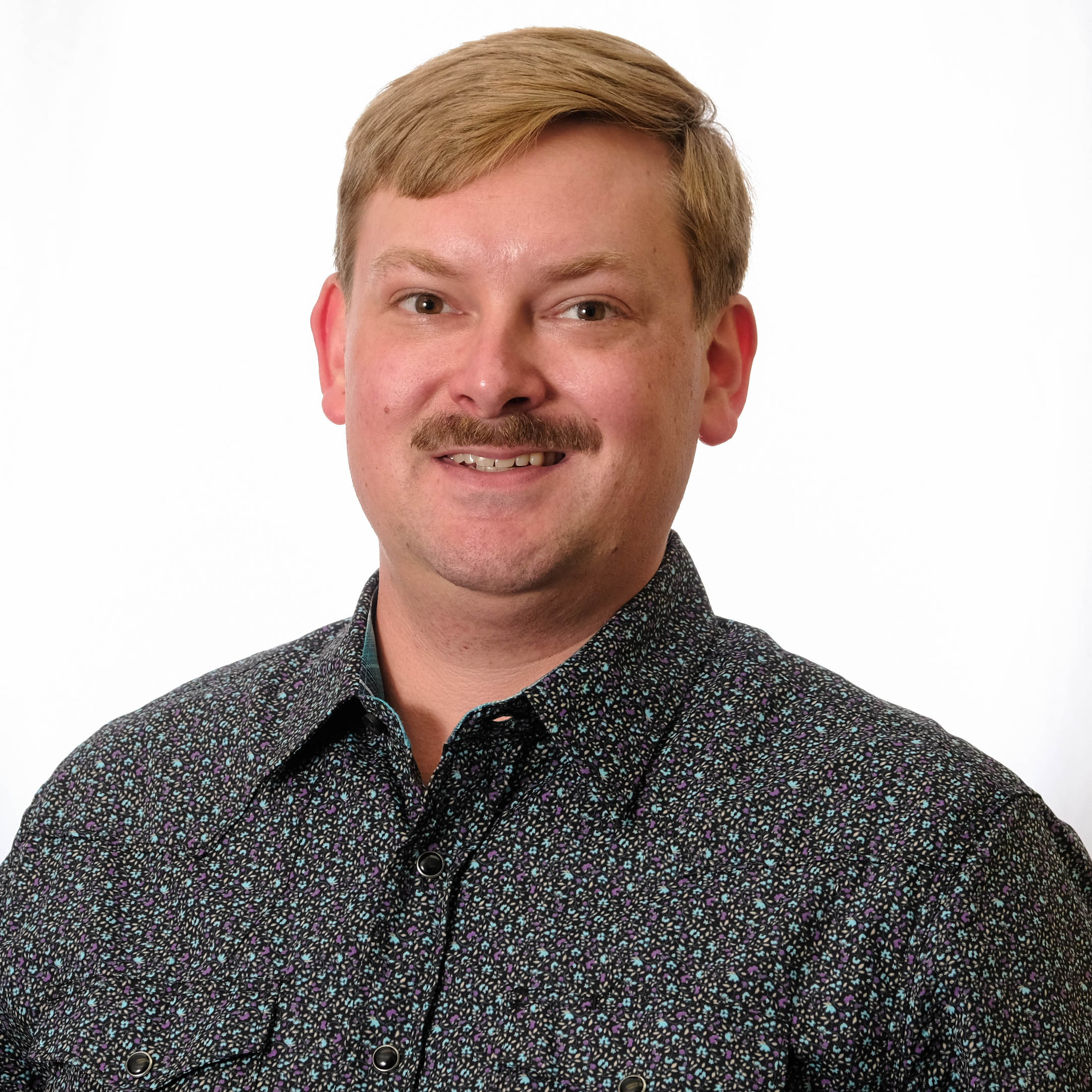 A headshot of Zack Sanders against a white background