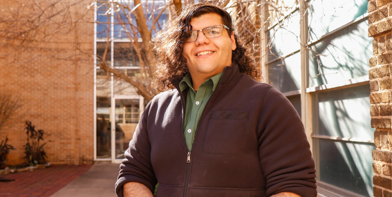 Kalep Glandon smiling to the camera in front of Davis Hall.