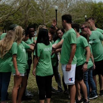 business class students in a group cheering after completing a 5k run project