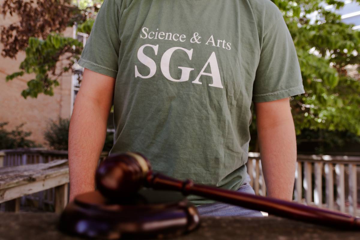 Close-up shot of a student wearing a USAO SGA shirt and a gavel in the foreground.